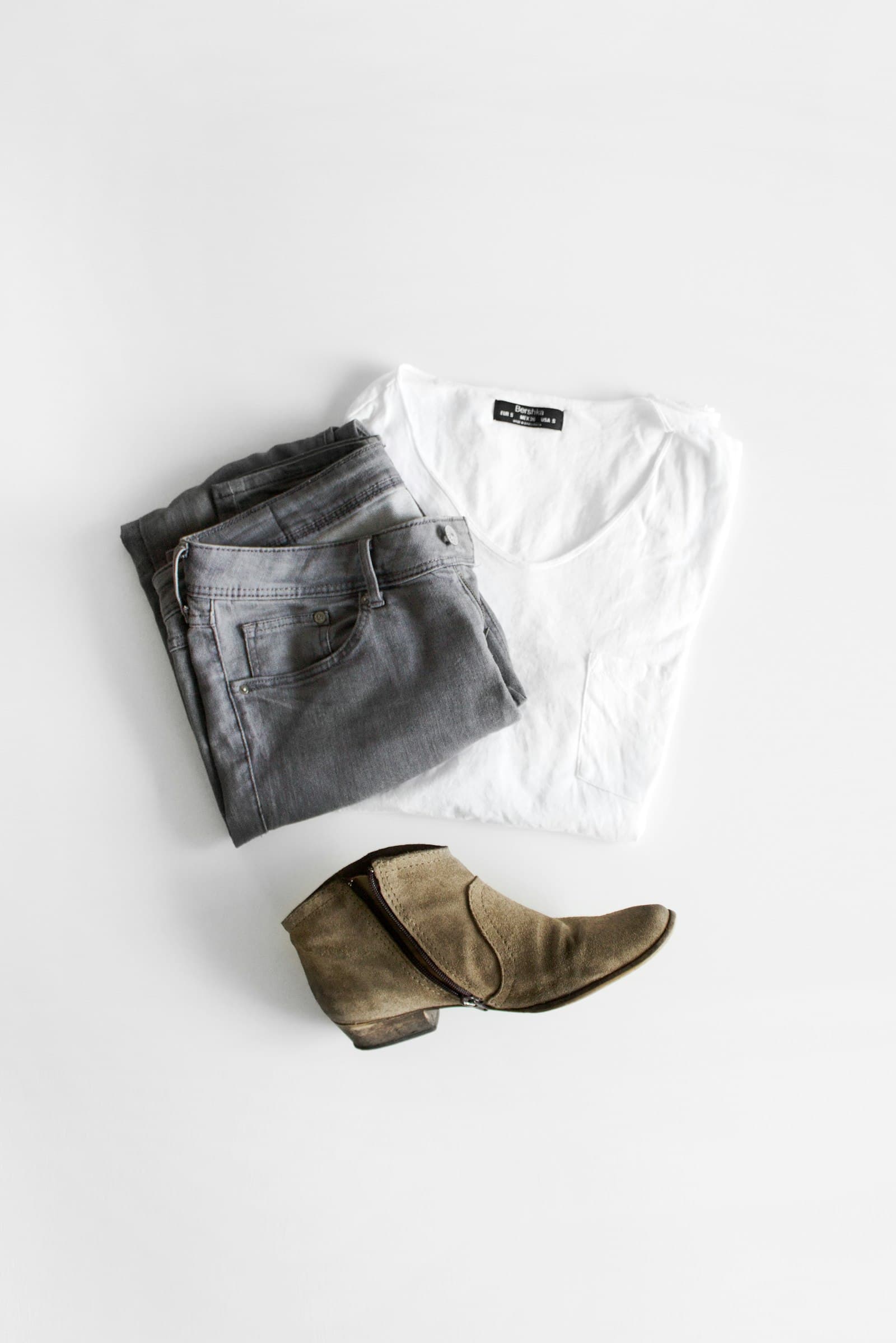 Outfit flat lay with grey jeans, white tee, and suede ankle boots