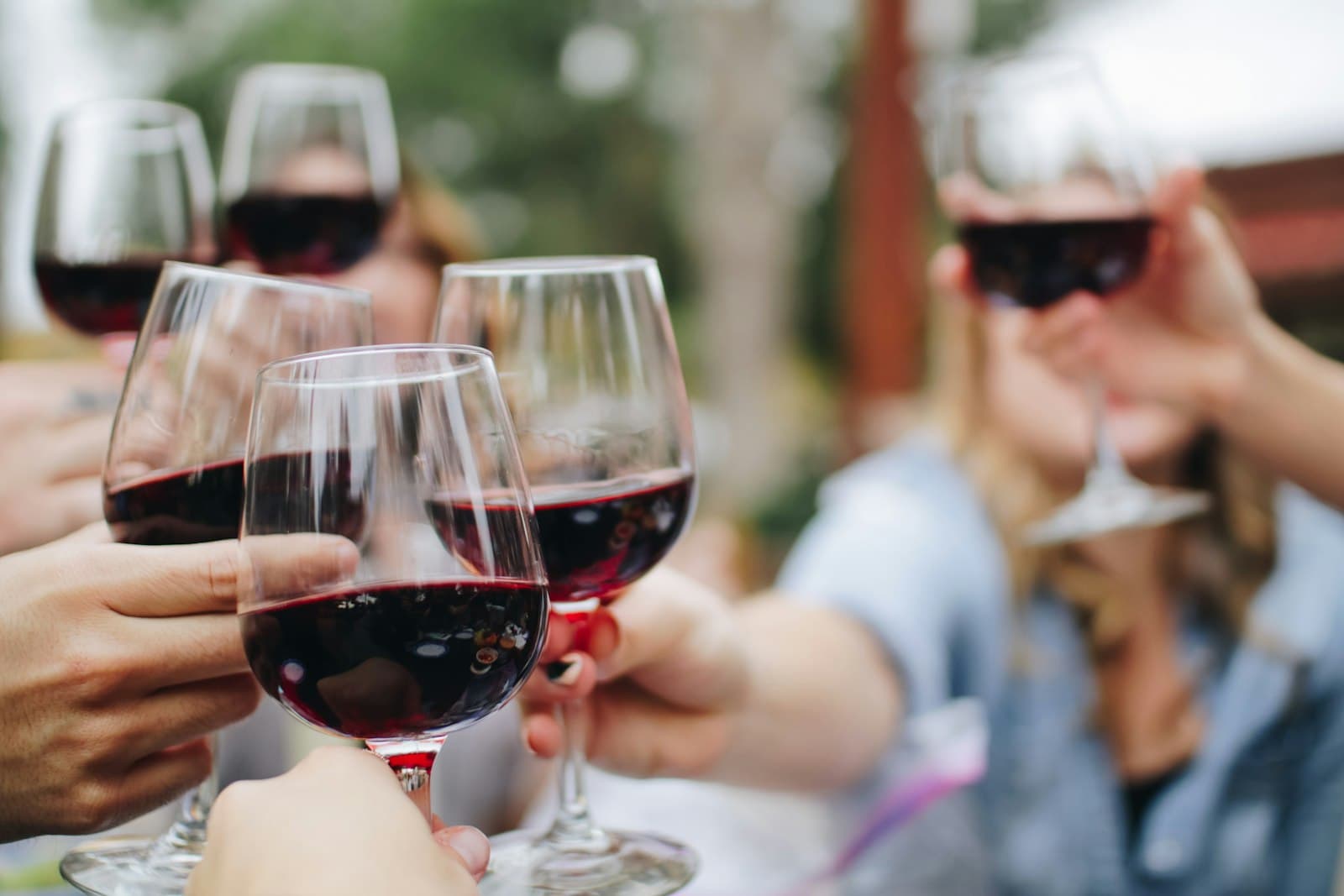 Friends raising glasses of wine together at an evening event
