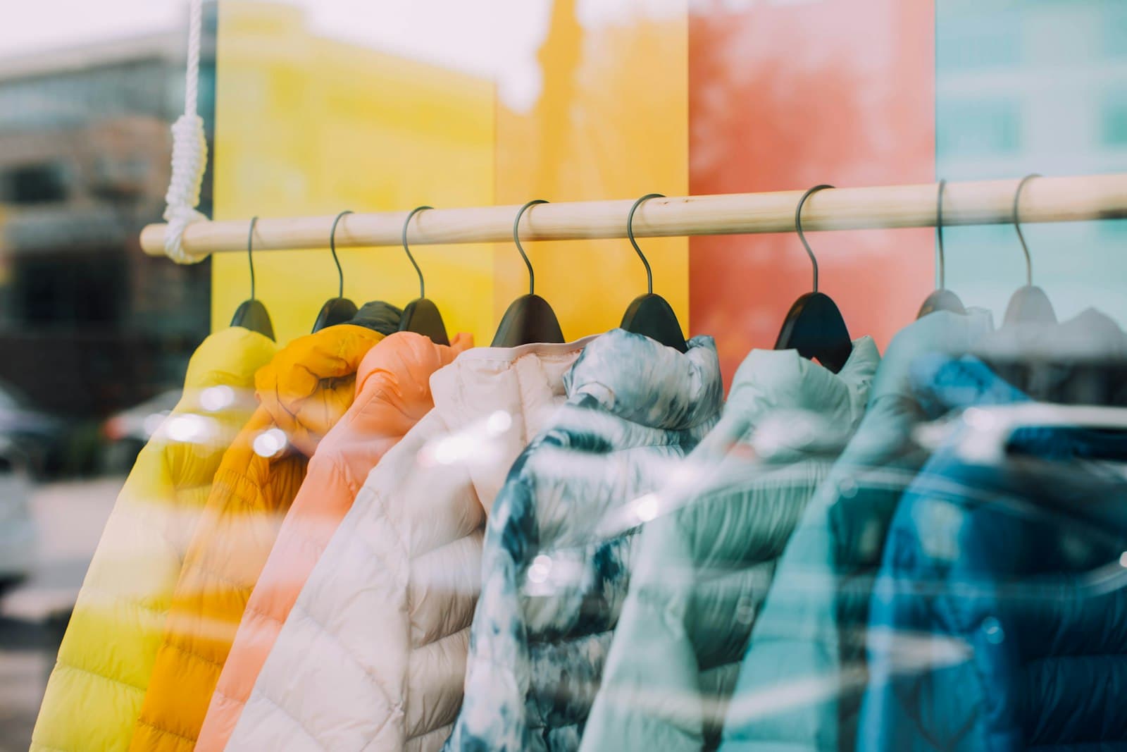 Rack of colorful jackets hanging in a boutique shop window
