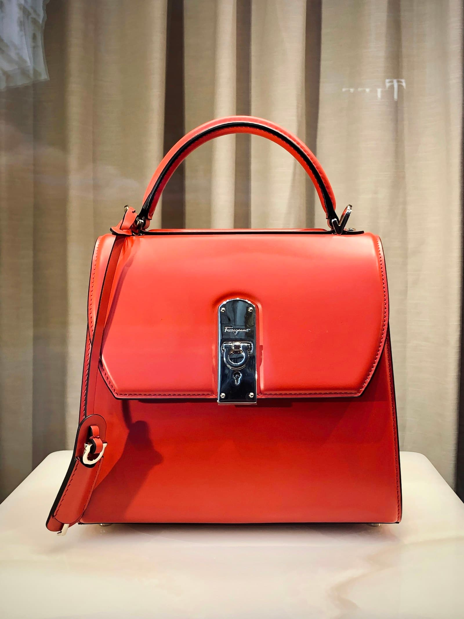 Structured terracotta leather top-handle bag with silver clasp